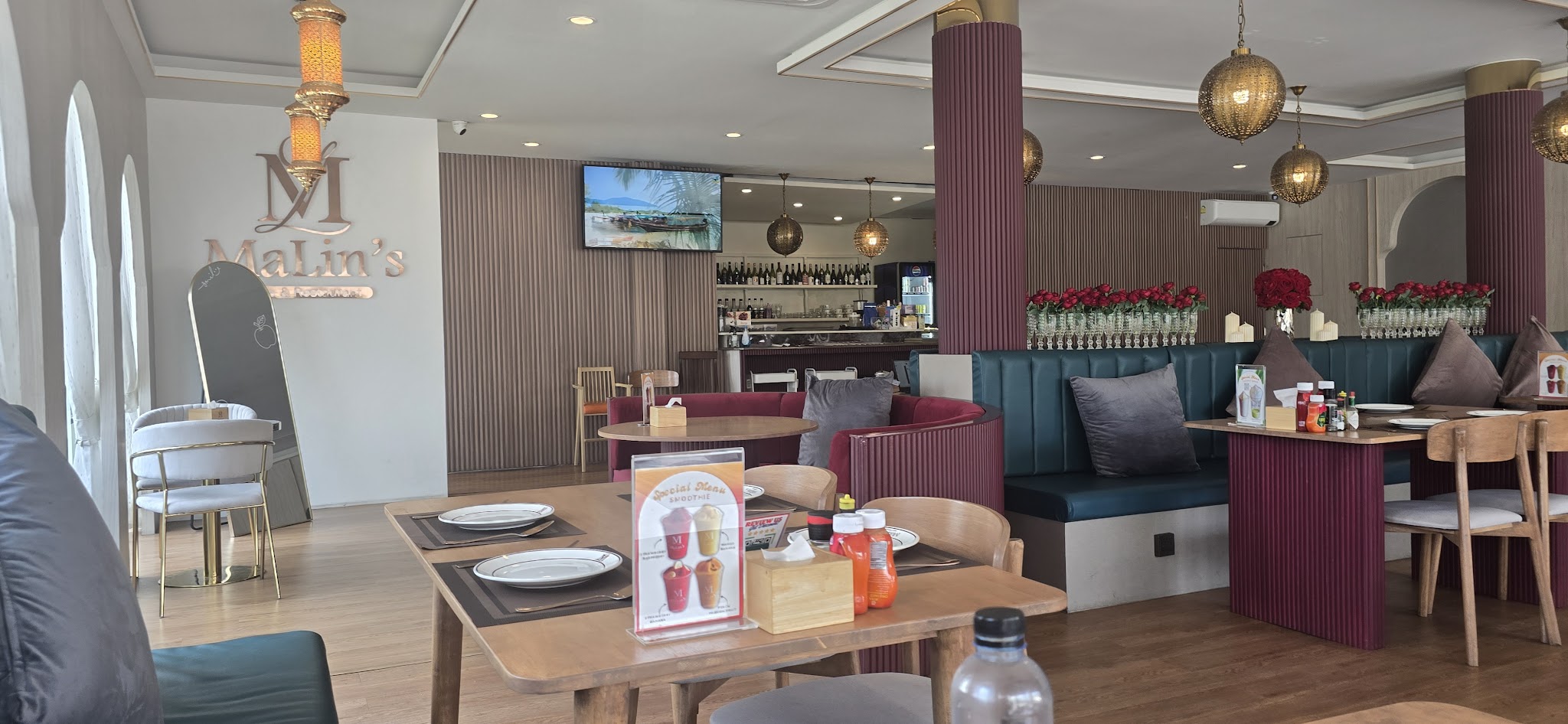 MaLin's Cafe & Restaurant interior with elegant Moroccan-style decor, teal booths, and golden pendant lamps